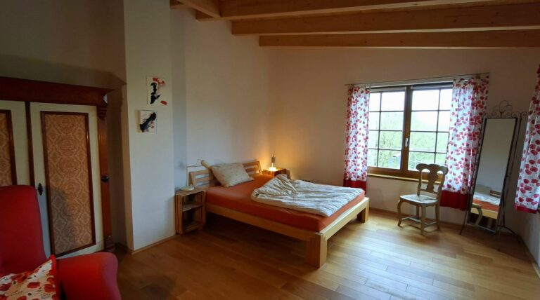Auenzimmer mit Doppelbett und Blick zum Garten